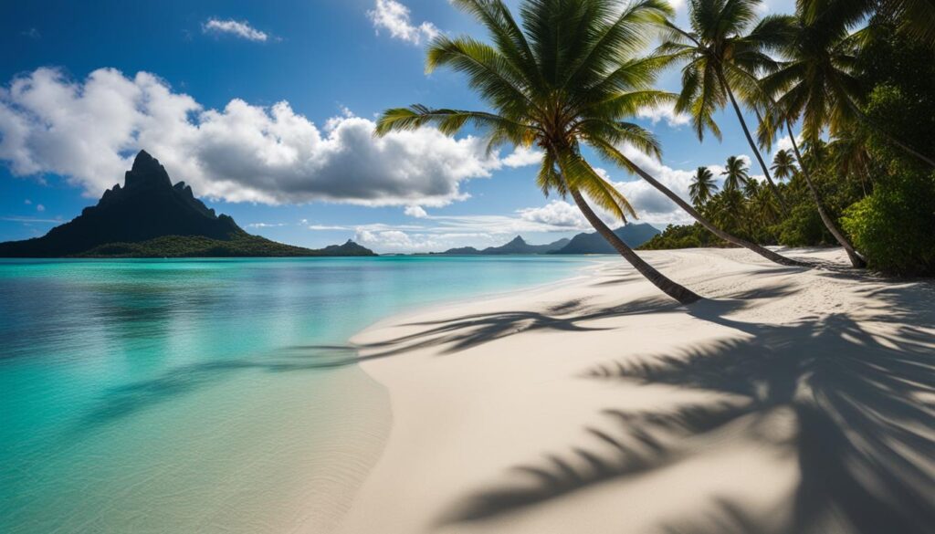 White sand beach with crystal clear turquoise waters and palm trees in Bora Bora